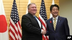 Menteri Luar Negeri AS Mike Pompeo (kiri), bersalaman dengan Perdana Menter Jepang Shinzo Abe di kantor Abe di Tokyo, 6 Oktober 2018.