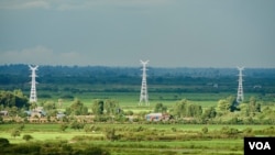 ເສົາໄຟຟ້າແຮງສູງຢູ່ຕາມເຂດຊົນນະບົດທີ່ນຳສົ່ງກະແສໄຟຟ້າໄປຂາຍໃຫ້ປະເທດເພື່ອນບ້ານ