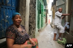 Residents emerge from their homes after Comoros armed forces members clear the medina of weapons and armed men at Mutsamudu, Oct. 20, 2018, on the island of Anjouan.