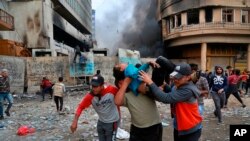 A wounded protester is carried to receive first aid during clashes with security forces on Rasheed Street in Baghdad, Iraq, Nov. 28, 2019. 