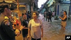 Residents talk to a policeman as floods advance into central Bangkok, Thailand, October 26, 2011.