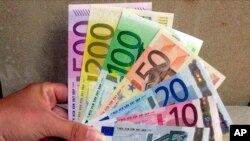 Seorang karyawan di Bank Sentral di Hanover, Jerman utara, memegang mata uang Euro, 30 Agustus 2001 (Foto: AP)