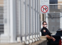 Amid concerns of the spread of COVID-19, a police officer wears a mask in Dallas, Wednesday, May 6, 2020.