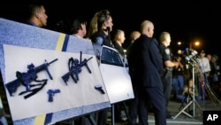FILE - Police photos of assault rifles and handguns are displayed during a news conference near the site of a mass shooting in San Bernardino, Calif., Dec. 3, 2015. A federal judge on June 4, 2021, overturned California's ban on assault weapons.