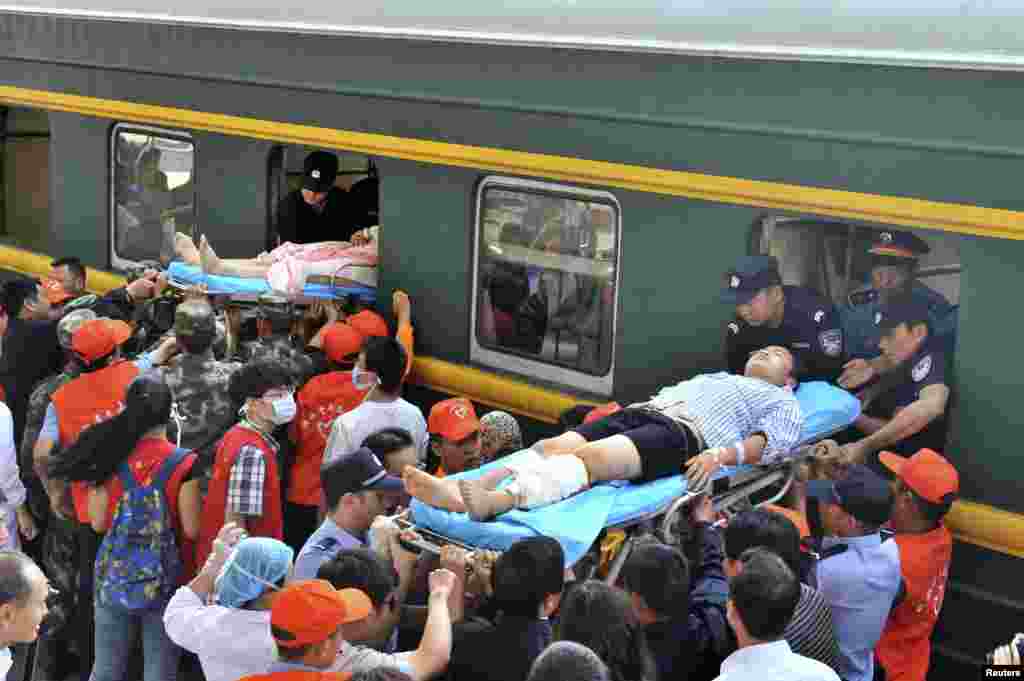People suffering from severe injuries are transported onto a train heading for Kunming to receive better medical treatment at a railway station in Zhaotong, Yunnan province, Aug. 5, 2014.