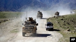 Arhiv - Snage SAD mimoilaze se sa patrolom afganistanskih komandosa u okolini Džalabada, istočno od Kabula, Afganistan, aprila 2014.