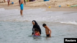 A Muslim woman wears a burkini, a swimsuit that leaves only the face, hands and feet exposed, on a beach in Marseille, France, August 17, 2016.