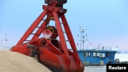 FILE - Imported soybeans are transported at a port in Nantong, Jiangsu province, China, Aug. 6, 2018. 