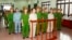 Doan Van Vuon (standing, 4th L), Doan Van Quy (standing, 2nd L) and Doan Van Sinh (standing, 3rd R) stand with policemen in front of the dock at a court during a verdict session in Hai Phong, April 5, 2013.