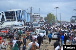 Palestinians carry bags of flour they grabbed from an aid truck near an Israeli checkpoint as Gaza residents face crisis levels of hunger, in Gaza City on Jan. 27, 2024.