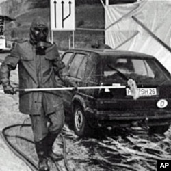 A 1986 file photo shows firefighters in protective gear washing a West German car near Herleshausen at the East German border after it arrived from Poland bearing radioactive fallout from the Chernobyl nuclear plant disaster