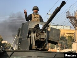 A member of Iraqi security forces stands in a military vehicle in Baladiyat district, east of Mosul during a fight with Islamic State, Jan. 9, 2017.
