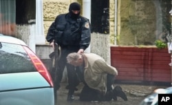 Teodor Chetrus is detained by a police officer in Chisinau, Moldova during a uranium-235 sting operation, June 27, 2011.