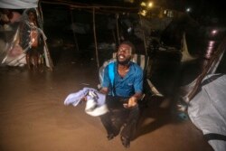 Penyintas gempa kuat yang melanda Haiti akhir pekan lalu, berusaha berlindung dari hujan deras di sebuah kamp pengungsi di Les Cayes, Haiti, 16 Agustus 2021. (AP Photo/Joseph Odelyn)