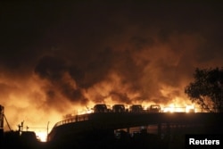 Vehicles are seen burning after blasts in the Binhai district of Tianjin, China, August 13, 2015.