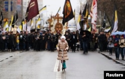 FILE - A girl rides a kick scooter as people walk during a "Russian March" demonstration, organized by the "Russian Coalition of Action" movement, seen in the background, on National Unity Day in Moscow, Nov. 4, 2013.