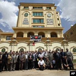 Egyptian Muslim Brotherhood members outside the party's new headquarters in Cairo, April 30, 2011