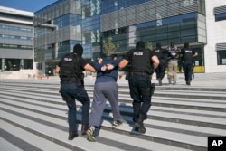 FILE - Kosovo police detain a terror suspect in the capital, Pristina, July 12, 2015..