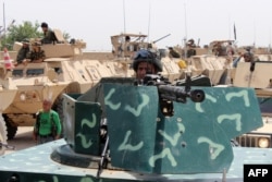 FILE - Afghan security personnel stand alert as they prepare for an operation against Taliban militants in the Aliabad district of Kunduz province, June 12, 2016.