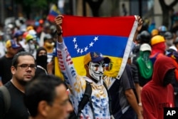 FILE - Demonstrators march against the government during protests in Caracas, Venezuela, June 29, 2017.