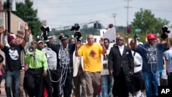 Protesters fill Florissant Road in downtown Ferguson, Mo. Monday, Aug. 11, 2014, marching along the closed street.