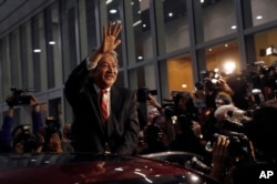 Hong Kong's Financial Secretary John Tsang waves to reporters as he leaves his office in Hong Kong, Dec.12, 2016.