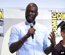 FILE - In this July 23, 2016 file photo, director Rick Famuyiwa speaks at the "Justice League" panel on day 3 of Comic-Con International in San Diego.