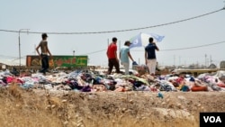 Some refugees sell things on the side of the road to try and generate a small income. Here clothes are being sold.(Phillip Wellman for VOA)