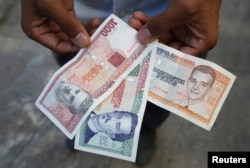 A man shows a new Cuban pesos outside a bank in Havana, Feb. 2, 2015.