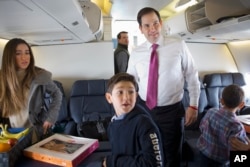 Republican presidential candidate, Sen. Marco Rubio, R-Fla. boards a plane with his family and staff to leave Manchester, N.H., Feb. 10, 2016, en route to South Carolina, after the New Hampshire primary. With him is daughter Amanda Rubio, 15, left, and s