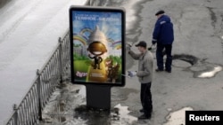 FILE - A worker puts up a billboard showing an image that resembles U.S. President Barack Obama, in Yekaterinburg, Russia, March 31, 2009. A Russian advertising agency has used an image resembling Obama to promote a new vanilla-and-chocolate ice cream.