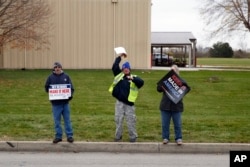 People watch as a motorcade carrying President-elect Donald Trump and Vice President-elect Mike Pence arrive for a visit to the Carrier factory in Indianapolis, Indiana, Dec. 01, 2016.