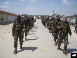 FILE - Members of Somalia's al- Shabab militant group patrol on foot on the outskirts of Mogadishu, March, 5, 2012.