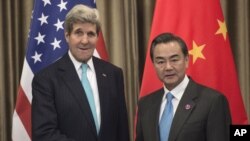 U.S. Secretary of State John Kerry, left, and Chinese Foreign Minister Wang Yi meet on the sidelines of the Asia-Pacific Economic Cooperation (APEC) meeting in Beijing Friday, Nov. 7, 2014.