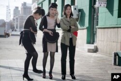 Waitresses wait outside a restaurant in Pyongyang, North Korea, April 12, 2017.