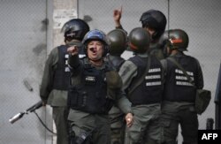 Members of the Bolivarian National Guard throw tear gas againts protesters near Cotiza Bolivarian National Guard headquarter in Caracas, Venezuela, Jan. 21, 2018.