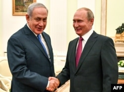 Russian President Vladimir Putin, right, shakes hands with Israeli Prime Minister Benjamin Netanyahu during their meeting at the Kremlin in Moscow, July 11, 2018.