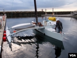 Joe Bersch prepping the Team Pure & Wild proa, a type of multihull sailing vessel, before the sail to Ketchikan, Alaska. (Tom Banse/VOA)