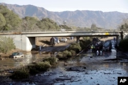Crews work on clearing Highway 101 in the aftermath of a mudslide, Jan. 13, 2018, in Montecito, Calif. Most of the people of the town, usually known for its serenity and luxury, were under orders to stay out as gas and power were to be shut off Saturday for repairs.