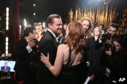 Leonardo DiCaprio, winner of the award for best actor in a leading role for “The Revenant” (l) and Julianne Moore appear backstage at the Oscars, Feb. 28, 2016, at the Dolby Theatre in Los Angeles.