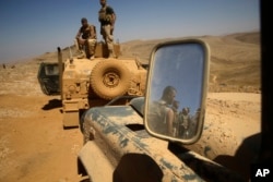 Lebanese soldiers rest on top of an armored personnel carrier during a media trip organized by the Lebanese army, on the outskirts of Ras Baalbek, northeast Lebanon Aug. 28, 2017. The Islamic State group has been expelled from its redoubt in the Qalamoun region close to the Syrian border.