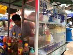 Yan Svan, a street vendor, is frying noodles for customers at the corner of Keto Melea hospital, in Phnom Penh, Cambodia, March 26, 2020. (Kann Vicheika/VOA Khmer)