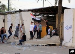 Supporters of Shi'ite cleric Muqtada al-Sadr walk over the blast walls surrounding Baghdad's highly fortified Green Zone, April 30, 2016. Dozens of protesters climbed over the blast walls and could be seen storming the parliament building.