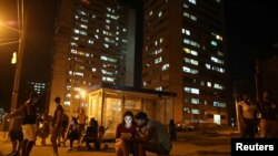 Carolina Gutierrez (center left), 17, and Neuil Valdez, 18, use mobile phones to connect to the internet at a hotspot in downtown Havana, Cuba, Dec. 12, 2016.