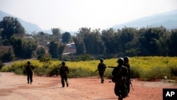 FILE - Myanmar army soldiers carrying weapons patrol on a road as part of operations against ethnic rebels, in Kokang, northeastern Shan State, more than 800 kilometers (500 miles) northeast of Yangon, Myanmar.