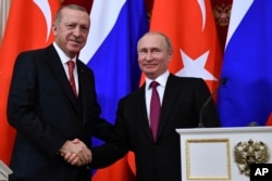 FILE - Russian President Vladimir Putin, right, shakes hands with Turkey's President Recep Tayyip Erdogan after their joint news conference following the talks in the Kremlin in Moscow, Russia, Jan. 23, 2019.
