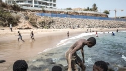 La jeunesse sénégalaise se détend sur la célèbre plage de Mermoz devant un nouveau chantier à Dakar, le 27 juin 2020.
