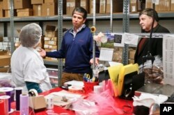 Republican Rick Saccone, right, and Donald Trump Jr., talk with chocolate workers as they take a tour of Sarris Candies during a campaign stop in Canonsburg, Pennsylvania, March 12, 2018.