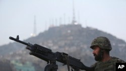 FILE - An Afghan soldier stands guard in Kabul.