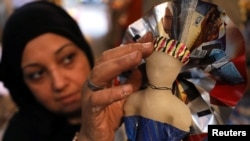 Seorang perempuan menghias permen berbentuk boneka di sebuah pasar menjelang Maulid Nabi Muhammad SAW, di Kairo, Mesir, 12 November 2018.